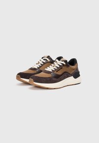 Brown and black athletic shoes with suede and mesh materials, featuring white laces, a textured sole, and a cushioned collar for comfort.