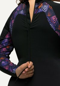 Zwarte wetsuit met kleurrijke patroonmouwen in paarse, oranje en witte geometrische ontwerpen; voorzien van een rits aan de voorkant.
