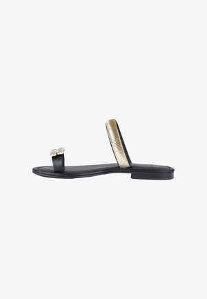 Sandalo nero piatto con passante per l’alluce decorato con gemme trasparenti e cinturino dorato metallizzato e texturizzato sulla parte centrale del piede.