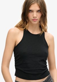 Zwarte mouwloze tanktop van lichtgewicht stof, met een ronde halslijn en een getailleerd ontwerp met een cropped zoom.