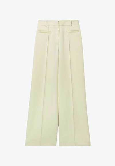 Pantalons larges de couleur crème claire, avec une taille haute, deux plis à l'avant et des poches latérales, offrant une texture lisse.