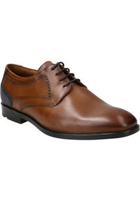 Chaussure habillée en cuir brun avec une surface lisse, un embout rond, des accents noirs et un système de laçage. Présente une couture décorative sur la tige.