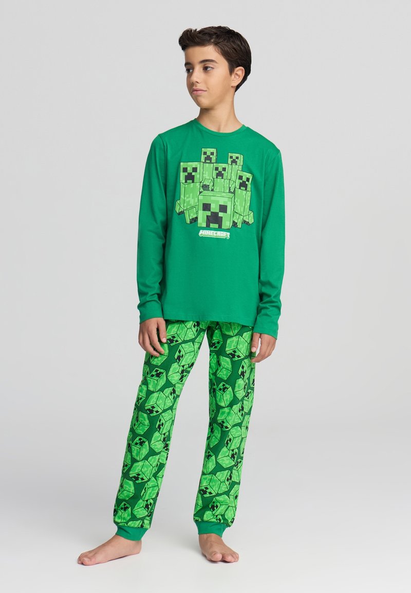 Pigiama verde a maniche lunghe con grafica a tema Minecraft e pantaloni da pigiama verdi con un motivo a Creeper ripetuto. Materiale in cotone morbido.