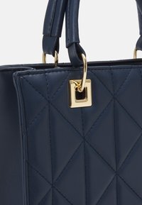 Borsa a tracolla blu navy trapuntata in pelle liscia con hardware dorato e un attacco a forma quadrata.