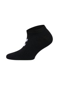 Svart ankelsocka tillverkad av ett slätt, töjbart material, med en vit logotyp på sidan och en ribbad resår.