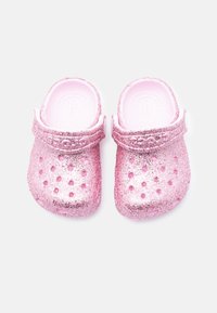 Ροζ γκλίτερ τσόκαρα με λείο φινίρισμα, οπές αερισμού και ρυθμιζόμενο λουράκι για ασφαλή εφαρμογή. Στρογγυλερή μύτη και μαλακό εσωτερικό.