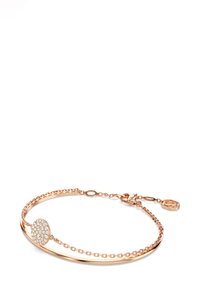 Braccialetto in oro rosa con un bracciale liscio, catena decorativa e un ciondolo rotondo con pietre trasparenti e scintillanti.