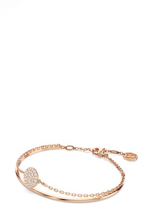 Braccialetto in oro rosa con un bracciale liscio, catena decorativa e un ciondolo rotondo con pietre trasparenti e scintillanti.