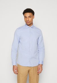 Lichtblauwe overhemd met lange mouwen in een gestructureerde stof, met een button-down kraag, met een subtiele logo en een knoopsluiting aan de voorkant.