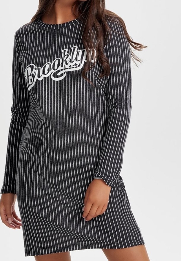 Pitkähihaisen, harmaaraidallisen mekon etuosassa on valkoinen teksti "Brooklyn". Kangas näyttää pehmeältä, jossa on ribbikuviointi ja rento istuvuus.