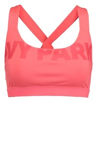 Reggiseno sportivo rosa realizzato in materiale elasticizzato, con una fascia larga e spalline incrociate. Nella parte anteriore è presente il testo "IVY PARK" in un design audace.