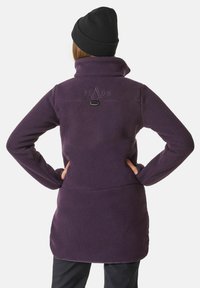 Lila Fleecejacke mit hohem Kragen, langen Ärmeln und einem Logo-Detail auf dem Rücken. Weiche Textur und mittellanges Design.