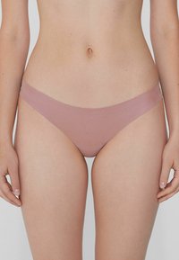 Růžový hladký tanga s minimalistickým designem a jemným pasem. Disponuje nízkým střihem.