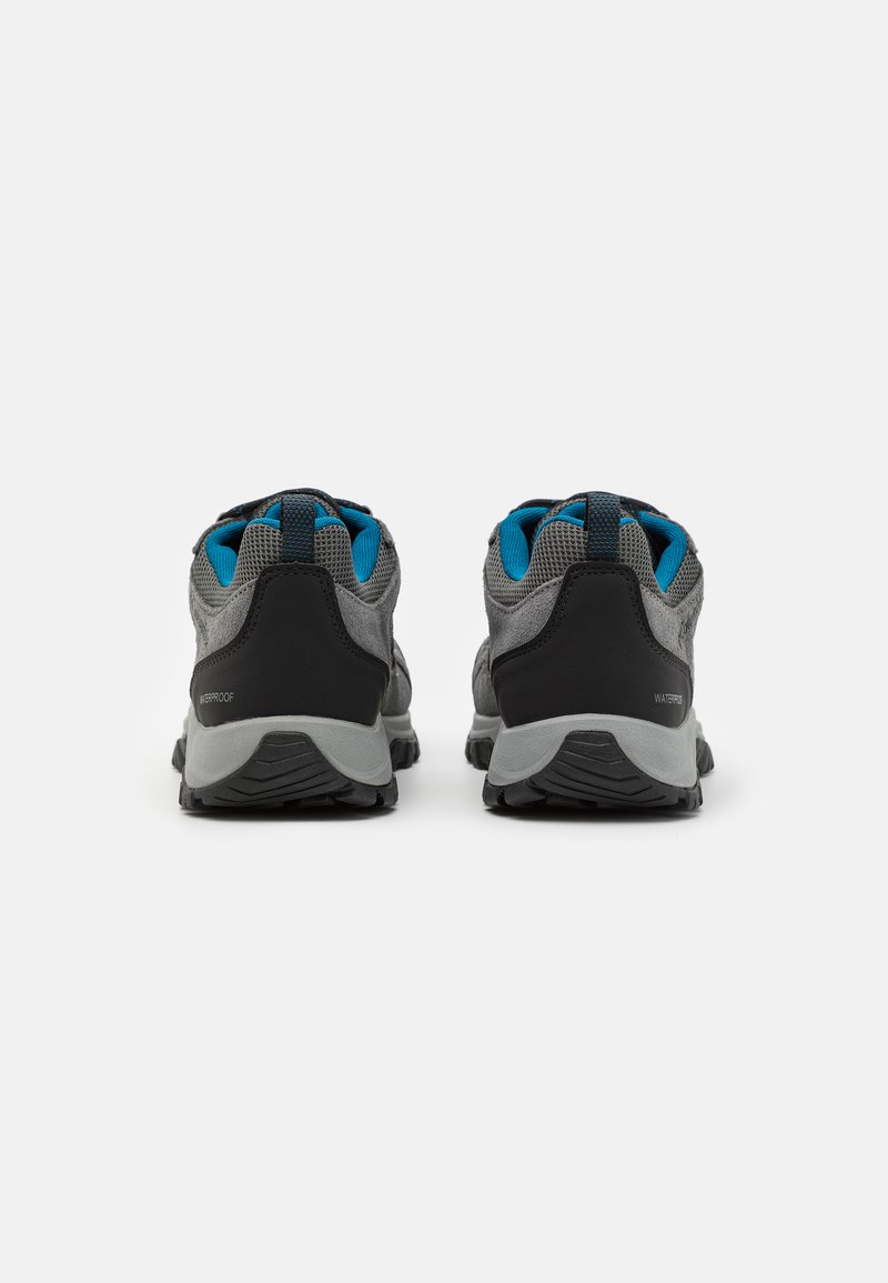 Grijze wandelschoenen met zwarte accenten, bovenwerk van mesh en een blauwe binnenvoering. Voorzien van waterproof tekst en een robuuste, gestructureerde zool voor grip.