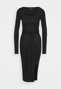 Robe noire côtelée à manches longues, encolure dégagée et ceinture à la taille. Comprend une fente latérale et une silhouette ajustée.