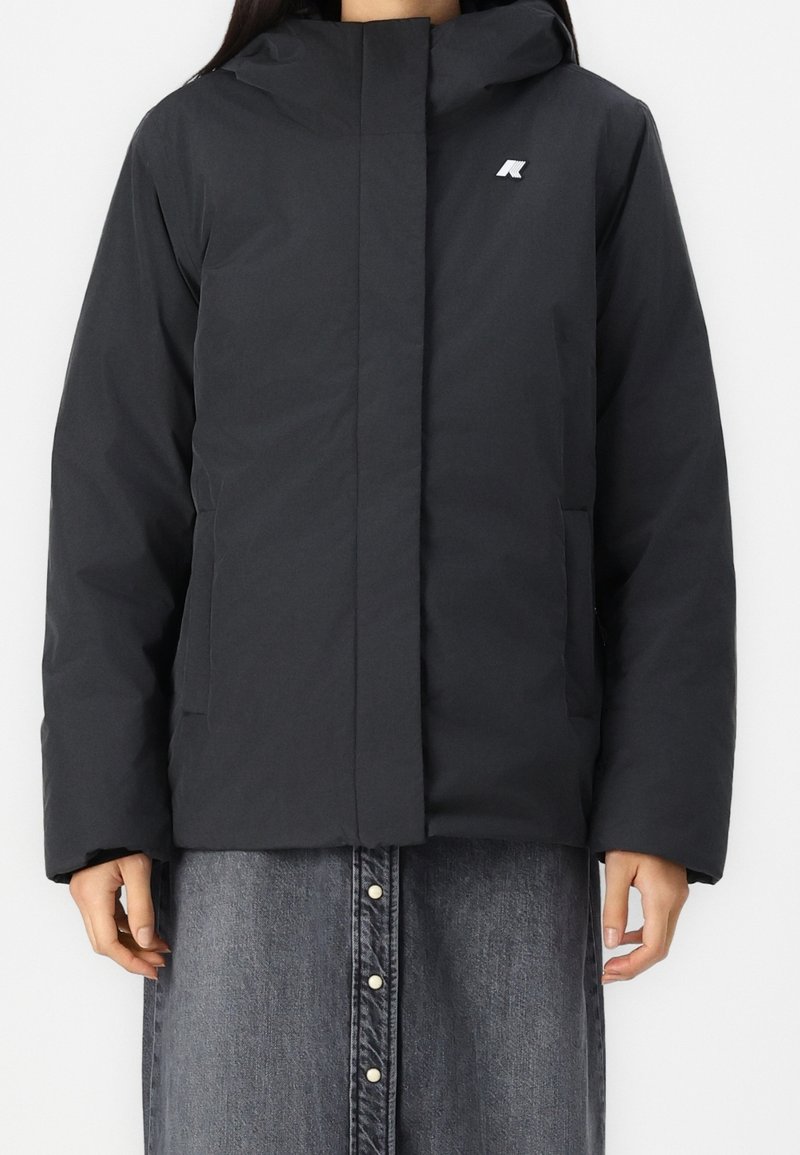 Černá zateplená bunda s předním zipem, kapucí a bočními kapsami. Na hrudi je malá nášivka. Hladká textura a moderní design.