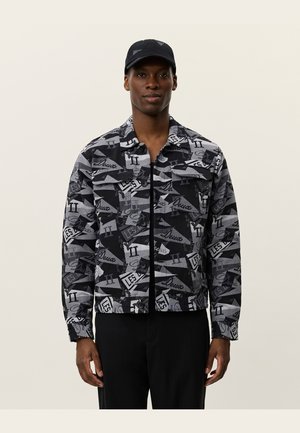 Black and gray patterned jacket with a button-up front, two chest pockets, and a modern design featuring various text graphics.