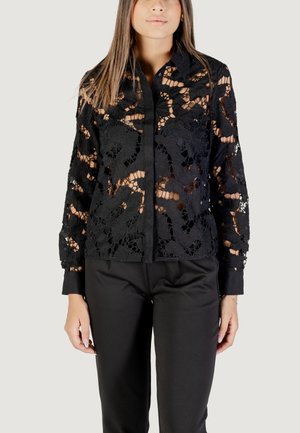 Blusa nera in pizzo con maniche lunghe, complessi intagli floreali e chiusura a bottoni; texture morbida con sezioni trasparenti e polsini neri solidi.