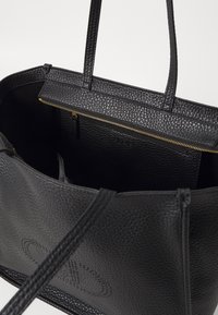 Borsa tote in pelle nera con texture, chiusura a zip, due manici e una fodera interna liscia. Presenta una tasca interna e un logo impresso.