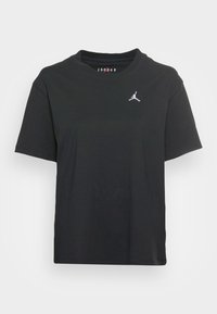 Sort bomulds T-shirt med korte ærmer, rund halsudskæring, med et hvidt broderet Jordan-logo på venstre bryst.
