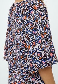 Vestito con motivo floreale caratterizzato da maniche corte a sbuffo e scollatura rotonda. I colori includono rosa, blu e arancione su uno sfondo chiaro.