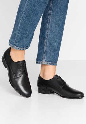 Zwarte leren dresschoenen met een gladde afwerking, spitse neus en vetersluiting. Kenmerkt subtiele stiksels en een lage, gestapelde hak.