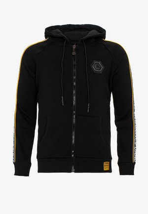 Schwarze Zip-Hoodie mit doppellagiger Kapuze, gelben Streifen an den Ärmeln, Fronttaschen und einem hexagonalen Logo-Patch auf der Brust.