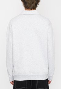 Sudadera gris claro, hecha de una suave mezcla de algodón, presenta un cuello, mangas largas y puños y dobladillo acanalados con una textura lisa y sencilla.
