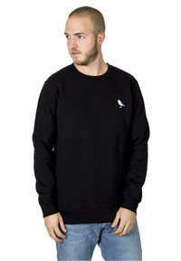 Sort sweatshirt i bomulds materiale, med rund halsudskæring og ribbede manchetter, samt et lille hvidt fugledesign på venstre bryst.
