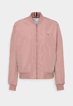 Veste bomber rose clair avec fermeture éclair sur le devant, col, poignets, ourlet côtelés, poches latérales et petit logo drapeau Tommy Hilfiger sur la poitrine.