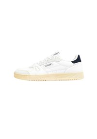 Zapatilla blanca con parte superior de ante y cuero, que cuenta con una suela de goma beige. Detalle en azul marino en el talón y un logotipo sencillo en el lado.