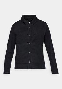 Giacca in fleece nera con chiusura a bottoni, colletto e tasche laterali. I dettagli di cucitura sono visibili lungo le cuciture per un tocco in più.