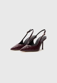 Burgundy slingback high heels with pointed toes, textured faux crocodile leather, and thin stiletto heels. Adjustable ankle strap.