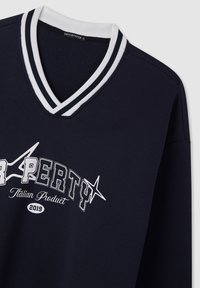 Felpa blu navy con colletto a V a righe bianche, grafica con stelle bianche e testo "Proprietà Prodotto Italiano 2019" sul davanti.