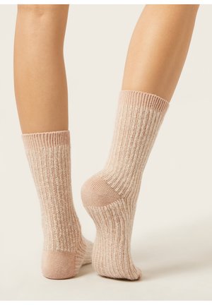 Knit socks in light pink with a ribbed texture and contrasting white stripes, featuring reinforced toes and heels for durability.