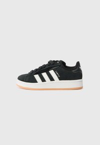 Black suede sneaker with white three-stripe design, round toe, black laces, and a rubber sole with a light brown bottom.