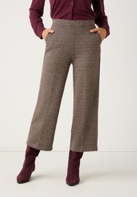 Wool blend, high-waisted trousers with a checkered pattern in shades of brown and red. Features side pockets and a relaxed, wide-leg fit.