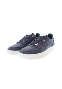 Námořnické kožené tenisky s bílými gumovými podrážkami, šněrovací design, perforované detaily po stranách a logo na jazyku.