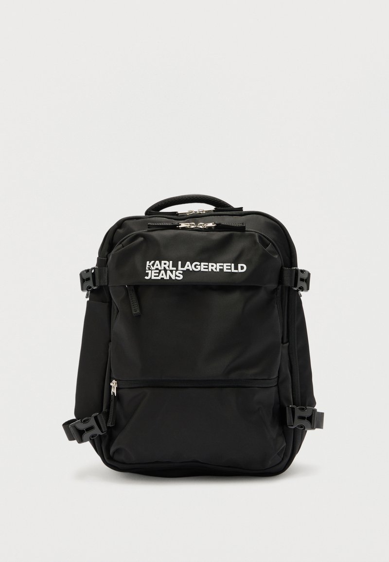 Μαύρο σακίδιο πλάτης Karl Lagerfeld Jeans με πολλαπλές θήκες με φερμουάρ, πλάγιες αγκράφες και κορυφαία λαβή σε λευκό φόντο.
