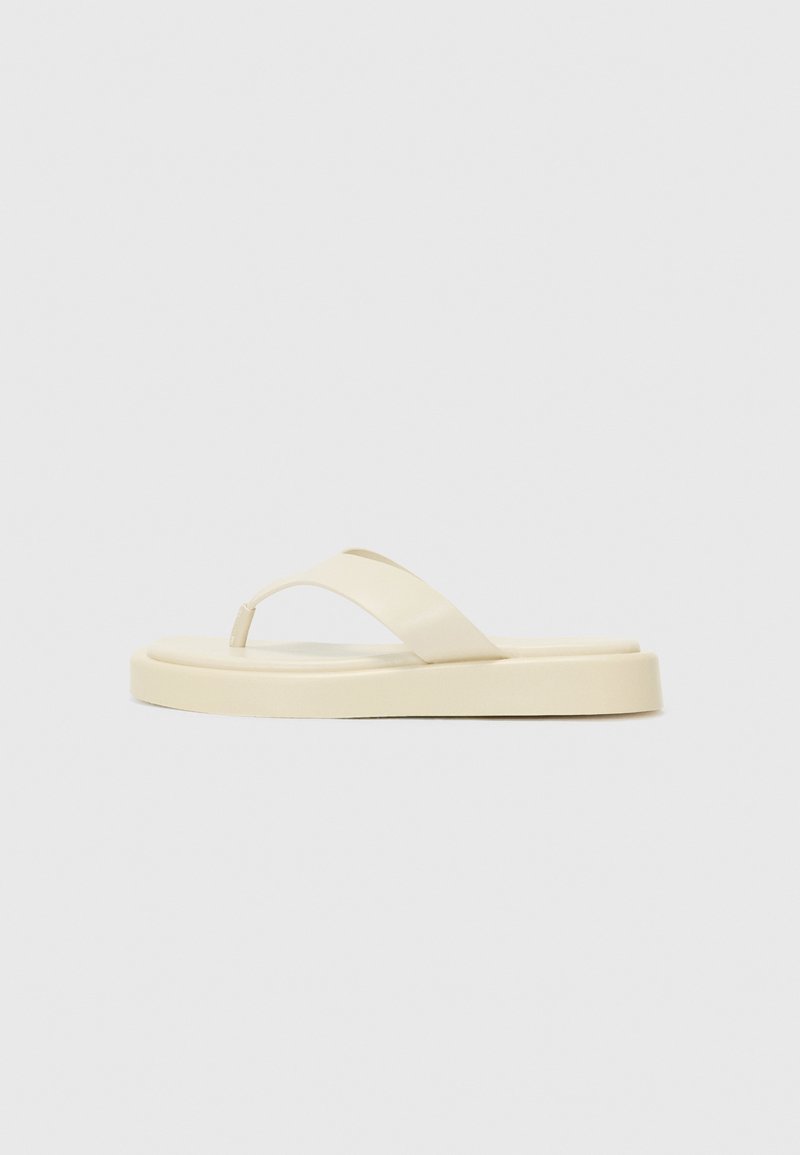Flat flip-flop sandals in light yellow. Made of smooth rubber with two diagonal straps and a thick sole for comfort and durability.