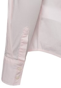 Light pink button-up shirt with a smooth texture, featuring a pointed cuff with two pearlescent buttons and a tailored fit at the sleeve.