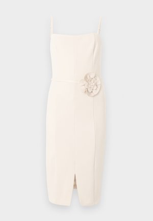 Robe midi couleur crème avec bretelles fines, taille cintrée, fente frontale et grande applique florale sur le côté droit.