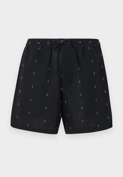 Schwarze Leinenshorts mit elastischem Bund und Kordelzug. Die Shorts sind mit kleinen weißen geometrischen Mustern im gesamten Stoff versehen.