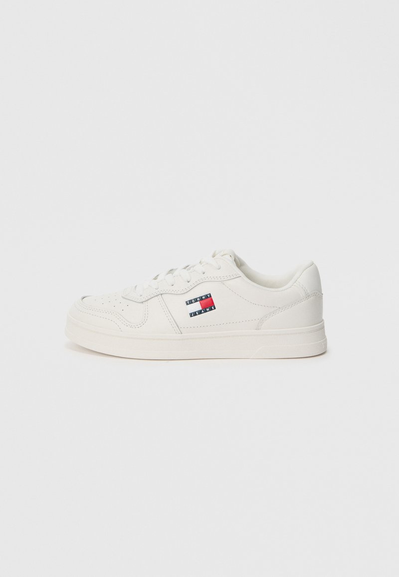 Baskets blanches avec un dessus en cuir lisse, bout rond et design bas, présentant un petit logo multicolore sur le côté.