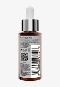 Brown dropper bottle of Maybelline self-tanning drops showing back label with usage instructions, warnings, barcode, and QR code.