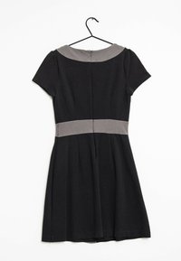 Svart kortärmad klänning med grå krage och midjeband som hänger på en svart galge mot en vit bakgrund.