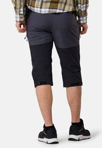Polvihlač under knee v temno sivi in črni tkanini, z zadržno žepom, nastavljivimi manšetami in Velcro trakovi za varen oprijem.