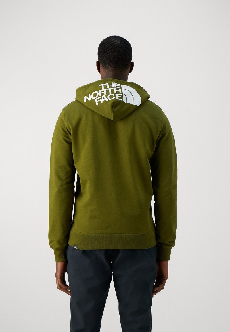 Olijfgroene hoodie met een voorste kangoeroezak, ribbels aan de mouwen en onderkant. Beschikt over een groot wit logo op de capuchon. Zachte stoftextuur.