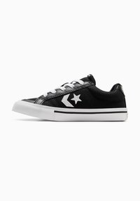 Schwarze Sneaker im Low-Top-Stil mit weißen Schnürsenkeln, weißem Stern und Chevron-Logo sowie dicke weiße Gummisohle mit schwarzem Streifen.