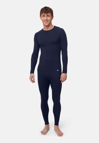 Dunkelblaues langärmeliges Thermo-Oberteil und passende Leggings aus einem dehnbaren, gerippten Stoff, mit figurbetontem Schnitt und minimaler Markenkennzeichnung.
